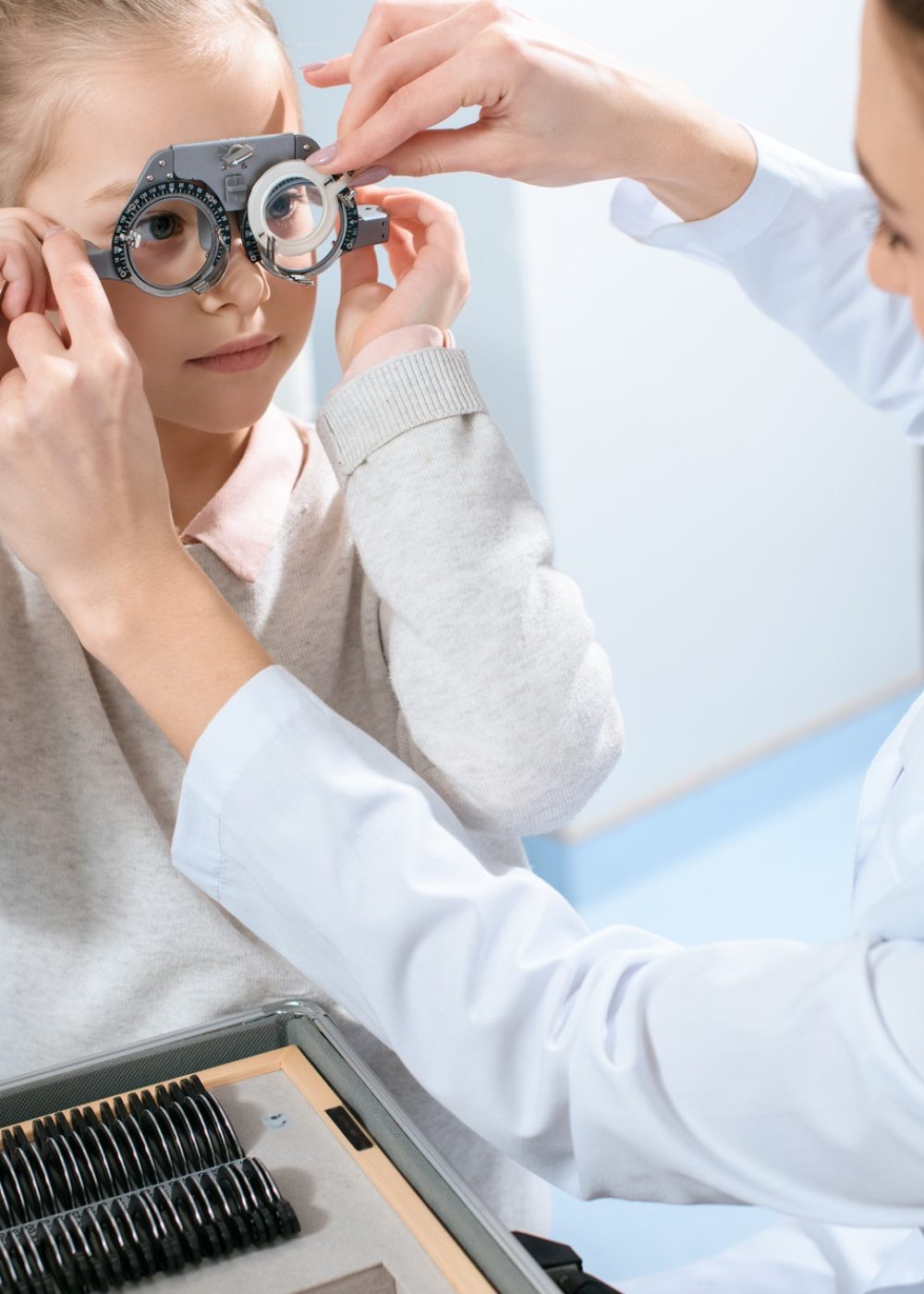 female-ophthalmologist-examining-kid-eyes-with-trial-frame-and-lenses-1